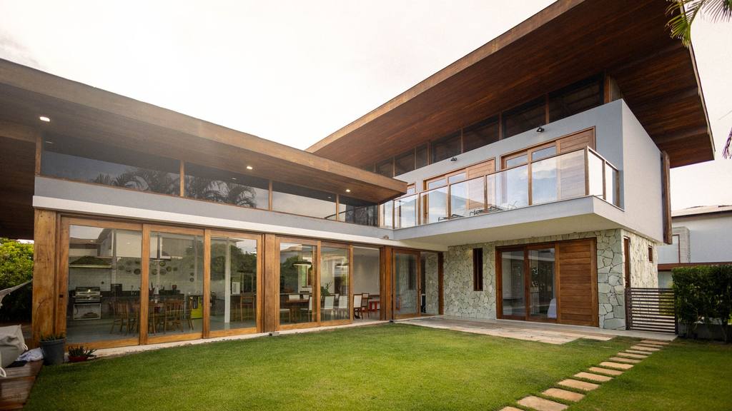 Contemporary house with large glazed doors, timber cladding and a lawn